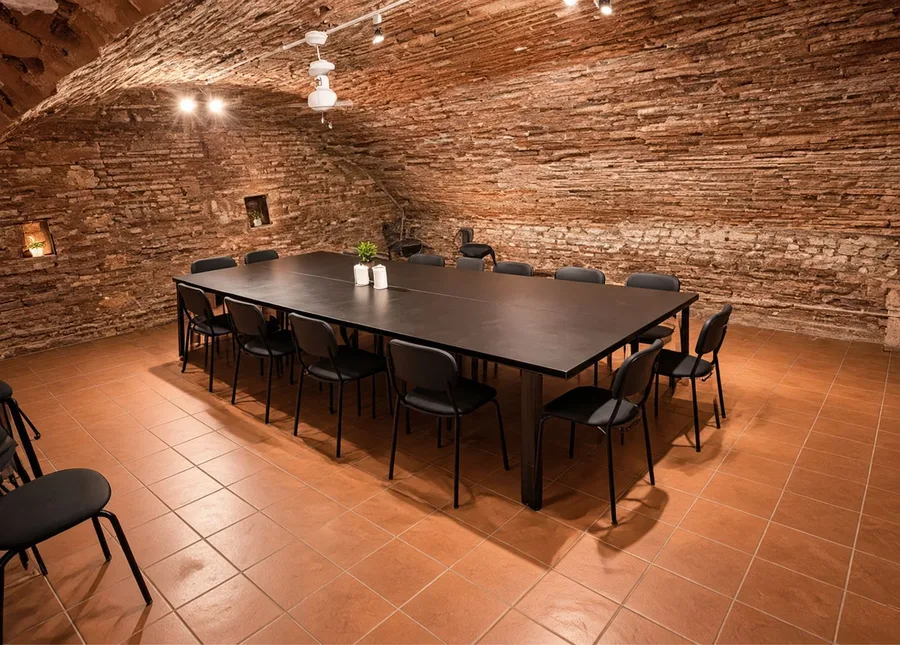 L’antre du Repaire du Phoenix à Montauban, salle voûtée en briques et sa grande table de jeu